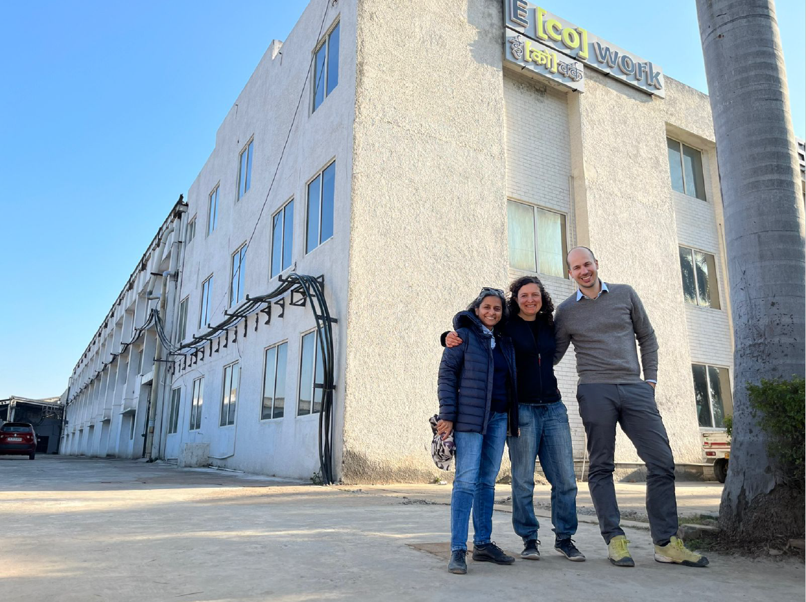 three persons standing outdoors in front of a building