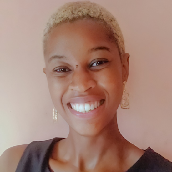 Black woman with blonde short hair smiling in the camera.