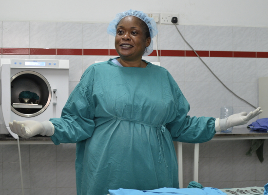 Black woman in protective clothes explaining something with her hands wide open.