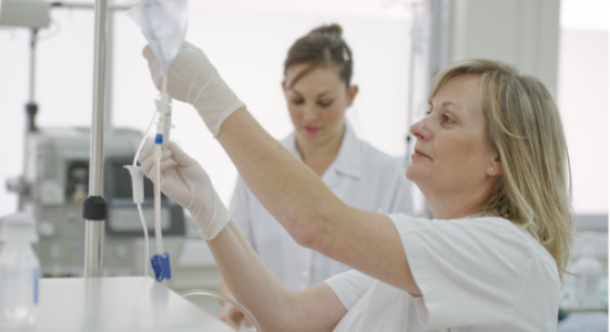 blond nurse replacing a drip in a hospital.