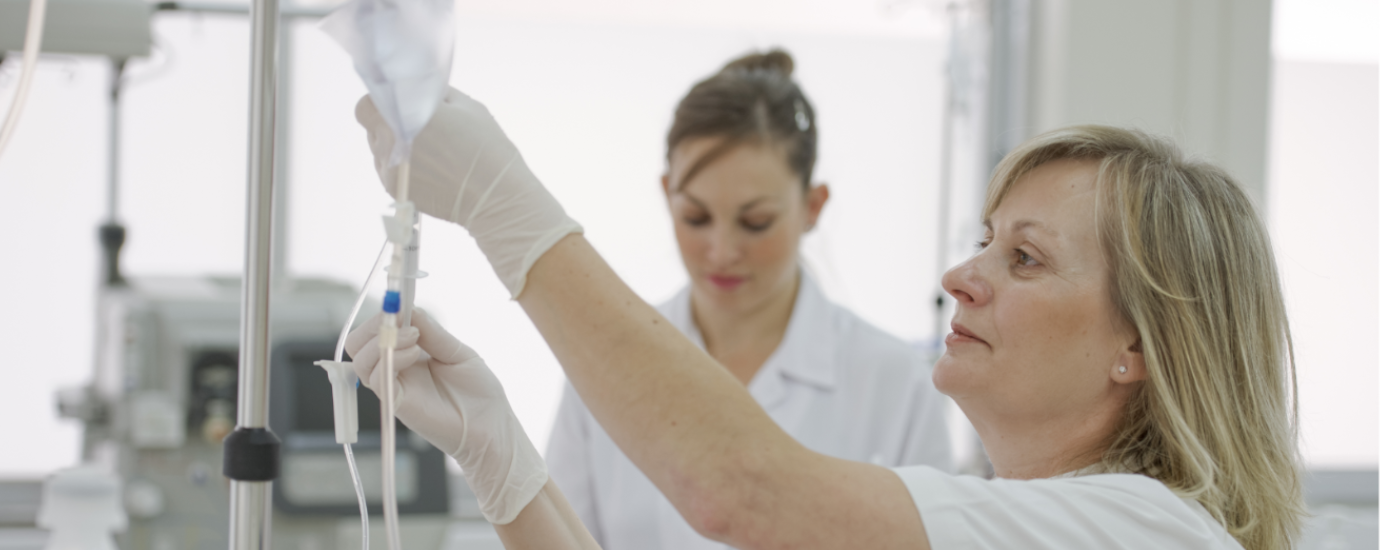 White nurse replacing a drip in a hospital.