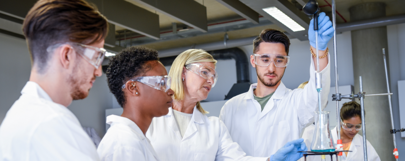 two women and two men working together with chemical labaratory tools.