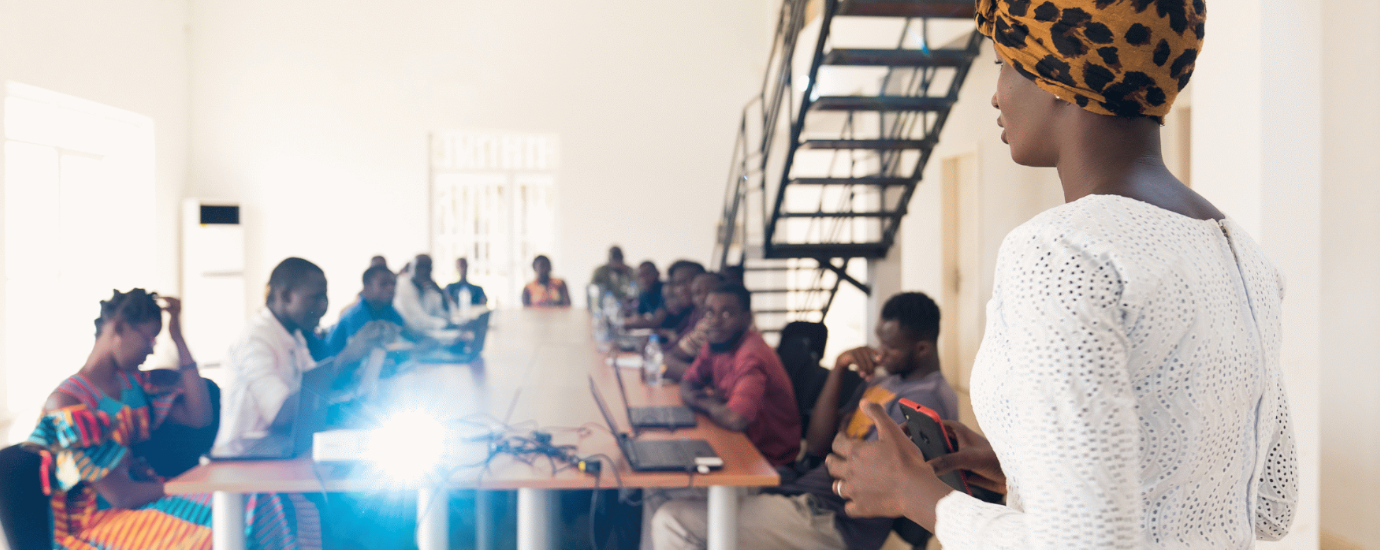 black woman presenting to a group of people facing the beamer.