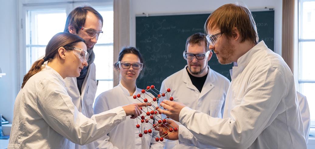 scientists in a group holding a molecular model