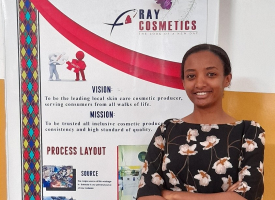 Young female founder from Ethiopia in front of roll-up of her company