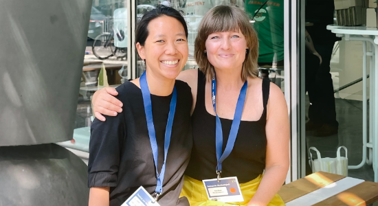 two women arm in arm smiling at the camera