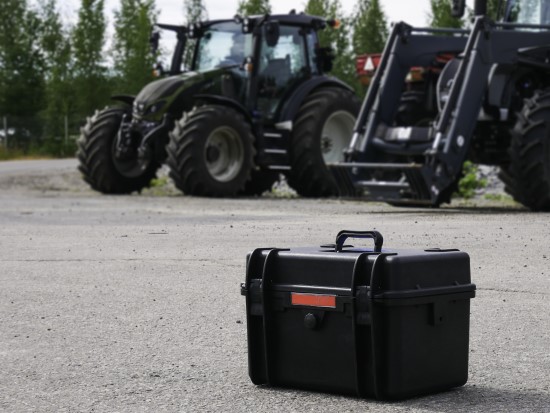 a suitcase in front of tractors