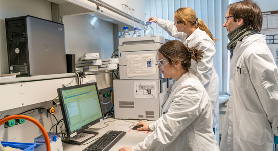 three people in lab coats in a lab