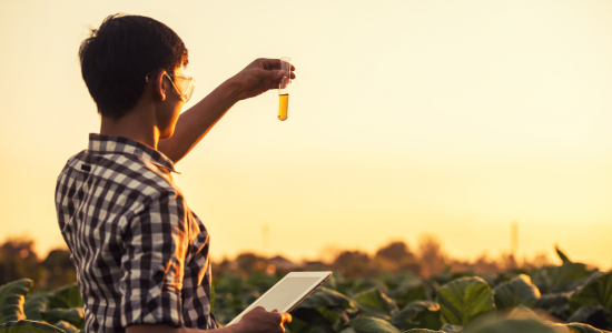 man on a field with a tablet and a liquid in his hand